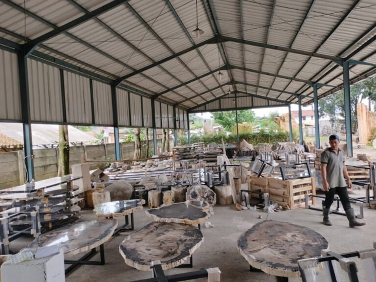 A professional warehouse scene showing high-quality Indonesian petrified wood slabs securely packed in wooden crates for international shipping.